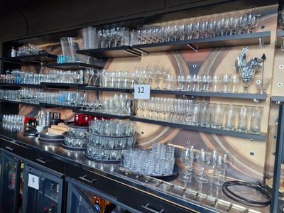 a bar with a lot of glasses on the shelves