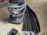 un aspirateur posé par terre à côté d'un tas de tuyaux