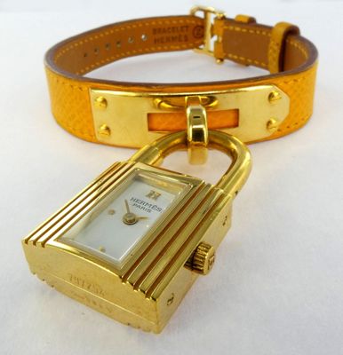 a gold watch with a lock attached to it