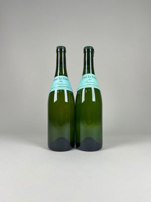 two bottles of wine sitting next to each other on a table