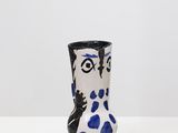 un vase blanc et bleu posé sur une table blanche