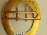 a gold brooch with writing on it hanging on a wall