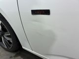 the door handle of a white car with a sticker on it