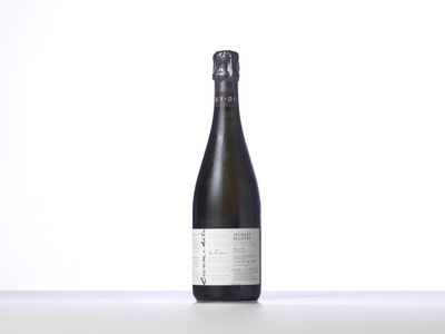 the bottle of wine is sitting on a white surface
