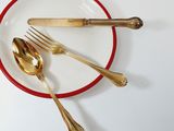 a red and white plate with silverware on it