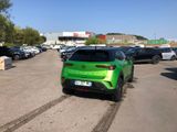 a green car that is parked in a parking lot