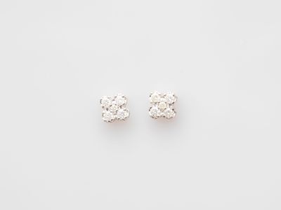 a pair of diamond stud earrings on a white background