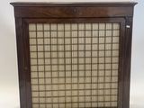 an old wooden cabinet with a glass door on top of it