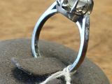 a silver ring on a rock with a string around it