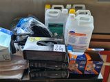 a pile of cleaning supplies on a table next to a couch