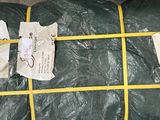 a green tarp wrapped in plastic and tied to a yellow line