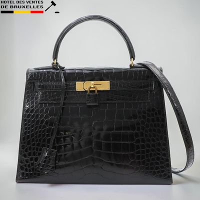 un sac à main en cuir de crocodile noir avec des finitions dorées