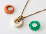 two necklaces and a ring on a white surface