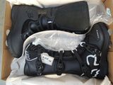 deux paires de chaussures dans une boîte posée par terre