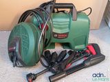 a green and black vacuum and other tools on the floor