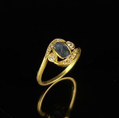 Bague en or jaune ornée d'un saphir de taille ovale cerné de…
