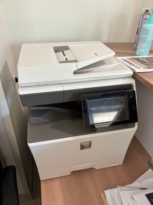 une imprimante posée sur un bureau à côté d'un ordinateur