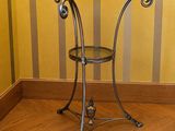 une petite table avec un plateau en verre posée sur un parquet