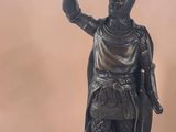 bronze statue of a man holding a bird and a bird perched on his arm