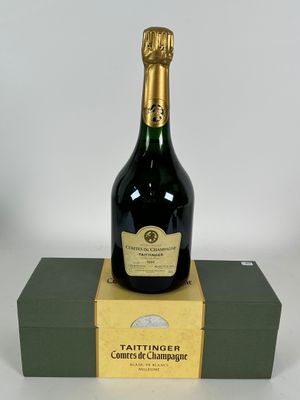 une bouteille de champagne posée sur une boîte verte