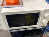 a microwave sitting on top of a stand with an orange cone on top of it