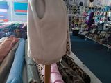 a mannequin in the middle of a room filled with clothing