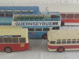 quatre petits bus en plastique posés sur une table
