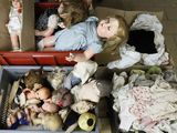 a lot of dolls in a box on the floor