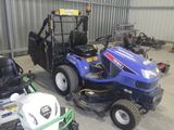 deux tondeuses à gazon et un tracteur dans un garage