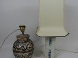 une lampe posée à côté d'un vase sur une table