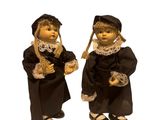 deux figurines représentant deux personnes vêtues de robes noires