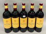 six bottles of red wine are lined up on a white surface