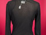 the shirt is black and has a long sleeve on a mannequin base