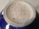 a blue vase with writing on it on a table