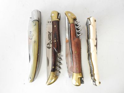 four different types of knives are lined up on a white surface