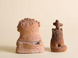 deux figurines en argile posées l'une à côté de l'autre sur une table