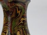 a close up of a vase on a white surface