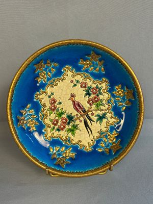 une assiette bleue ornée d'un oiseau et de fleurs