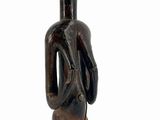 wooden statue of a man holding a bag on a wooden base