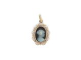 a gold pendant with a picture of a woman in a blue dress