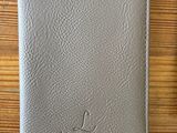leather wallet with a pen and pencil sitting on a wooden table