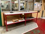 une table rouge avec un plateau en marbre, placée devant une fenêtre
