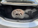 a tire in the trunk of a car with a wheel in it