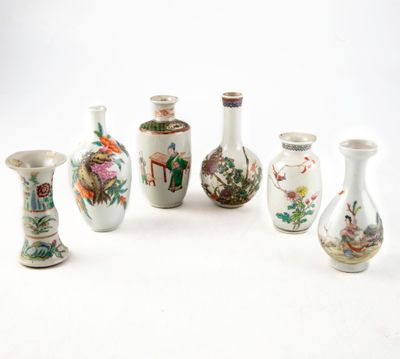 Plusieurs vases aux motifs variés sont disposés en rangée sur une surface blanche