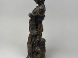 an antique bronze statue of a woman with a basket of flowers