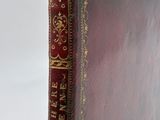 a close up of a book with a red cover on a white surface