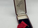 an image of a small medal with a red ribbon in a case