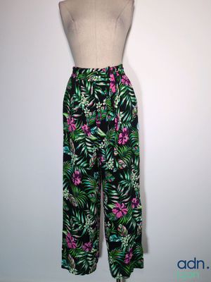 un pantalon à imprimé tropical noir et vert, orné de fleurs roses