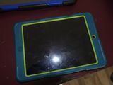 une tablette bleue et verte posée sur une table