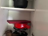 des placards sur lesquels sont posées des casseroles et des poêles, dans une cuisine